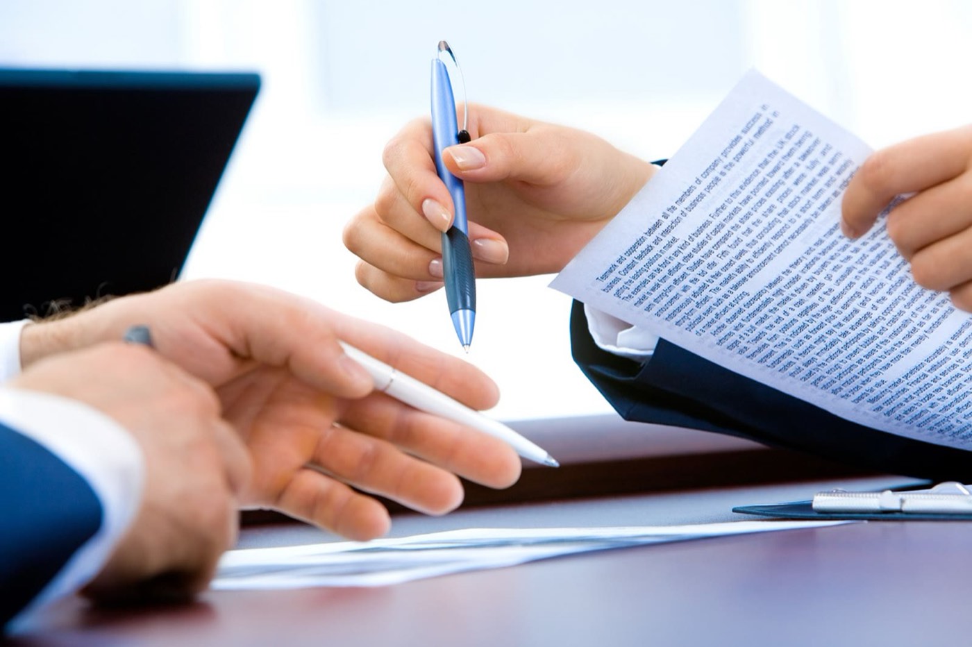 Duas pessoas revisando um documento impresso sobre a mesa